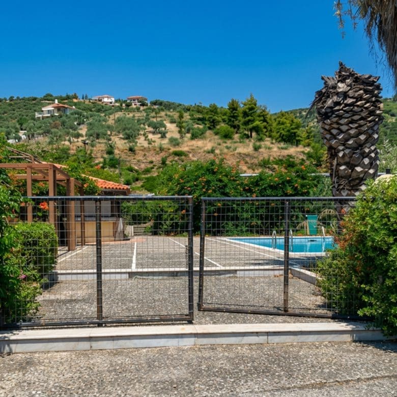 Entrance gate view towards pool and outdoor area at hotel property in Limi, Evia