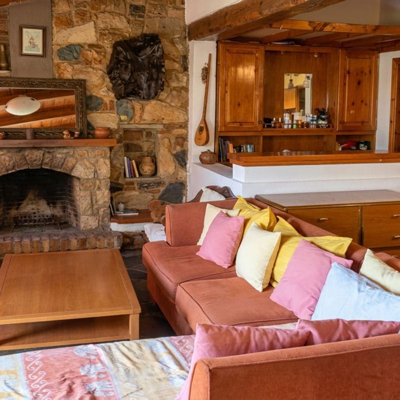 Lounge area with stone fireplace and bar counter in hotel property in Limi, Evia