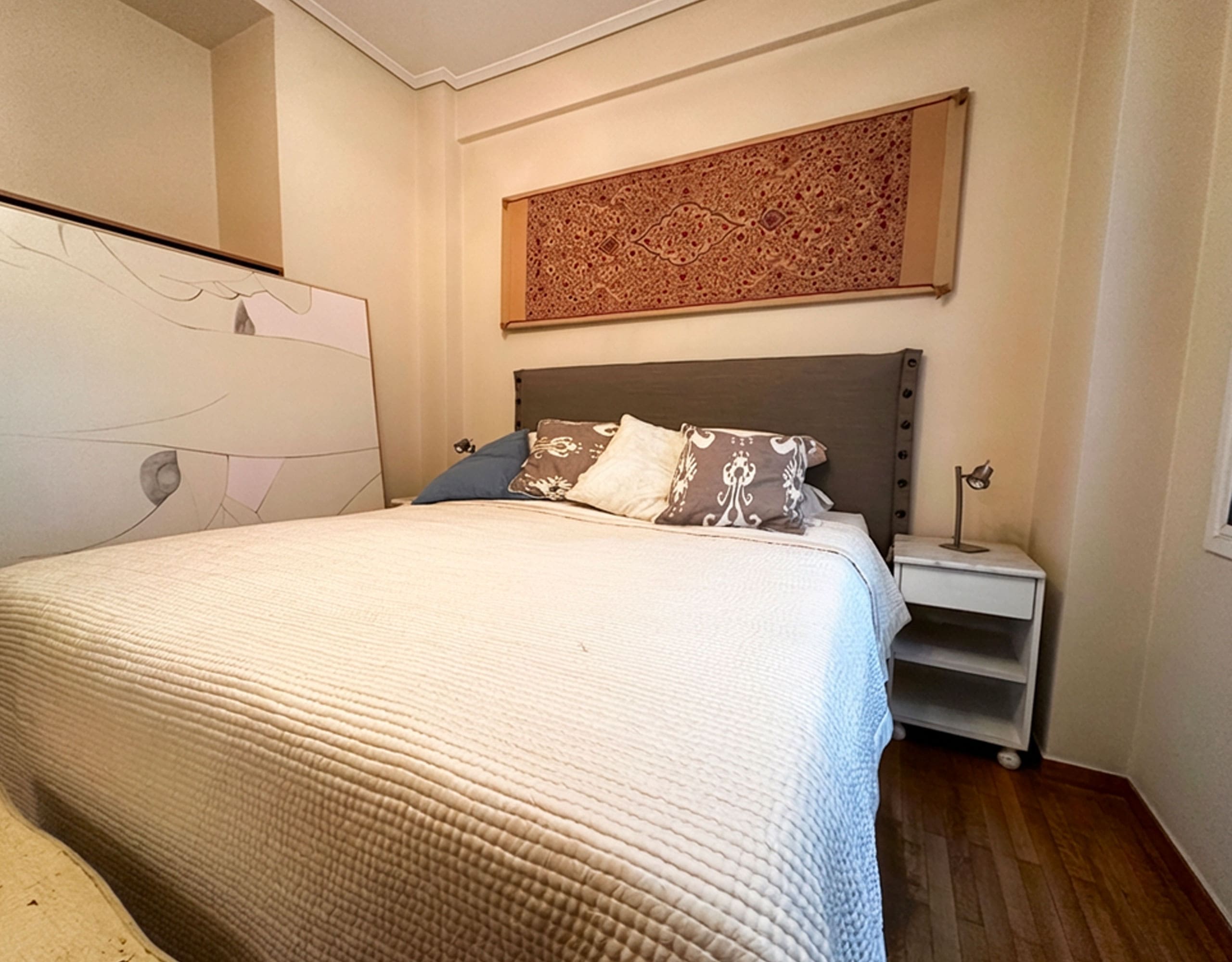 Main bedroom with double bed and bedside table in Ampelokipoi renovated apartment