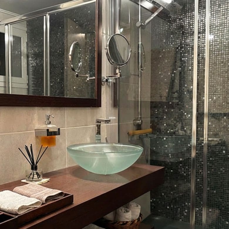 Bathroom with glass shower enclosure and modern vanity sink in Ampelokipoi renovated apartment