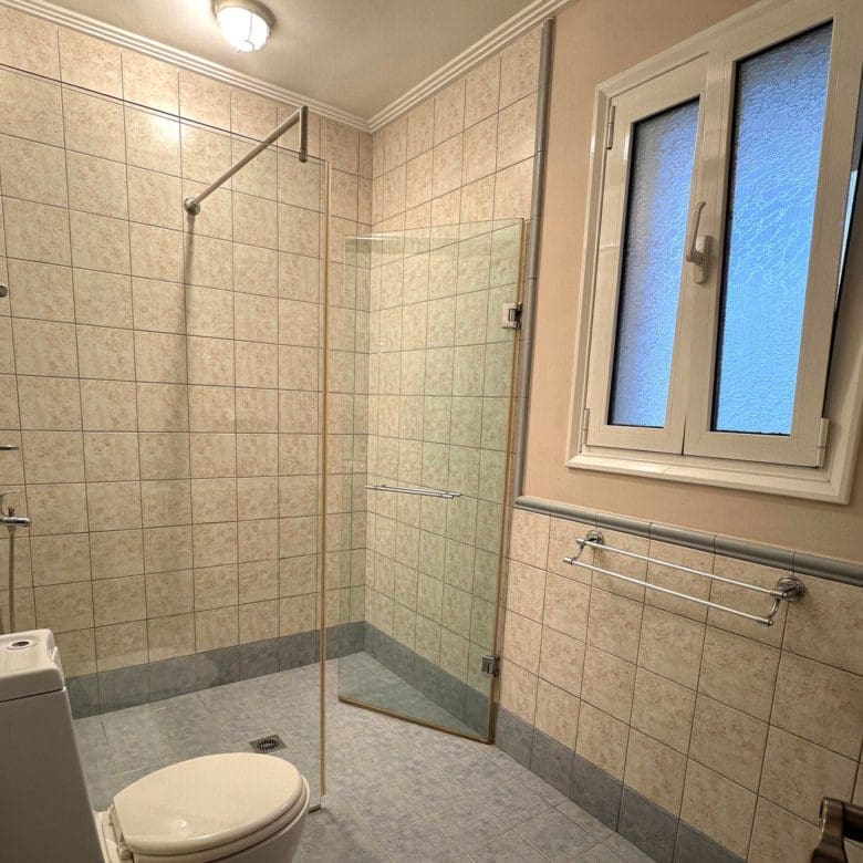 Spacious tiled bathroom with shower area in the Eretria maisonette