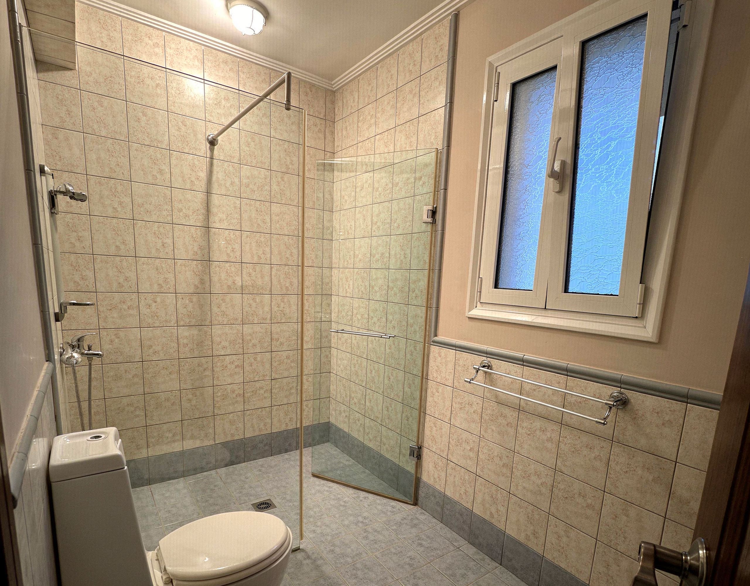 Spacious tiled bathroom with shower area in the Eretria maisonette