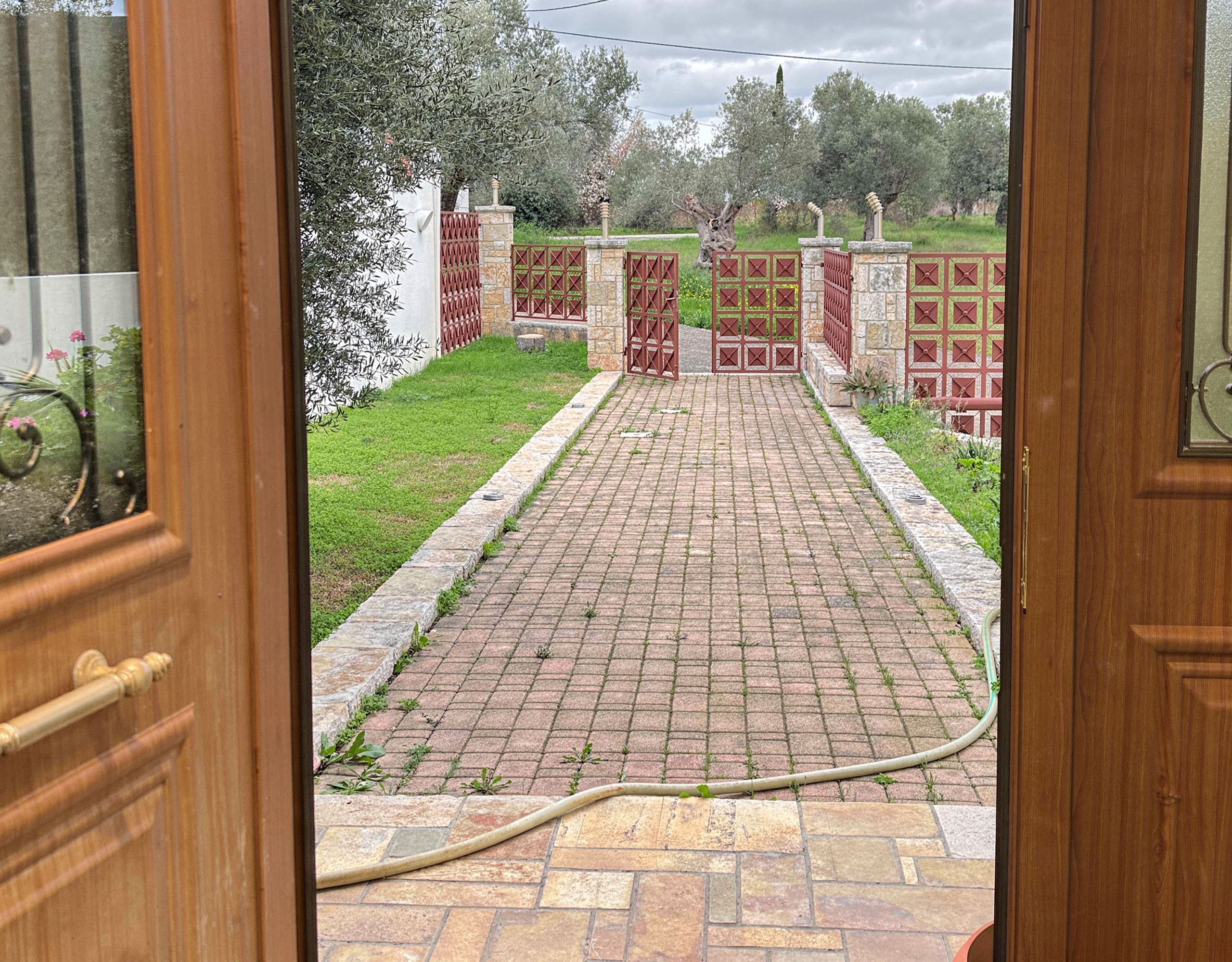 View of the driveway and entrance path from inside the maisonette in Eretria