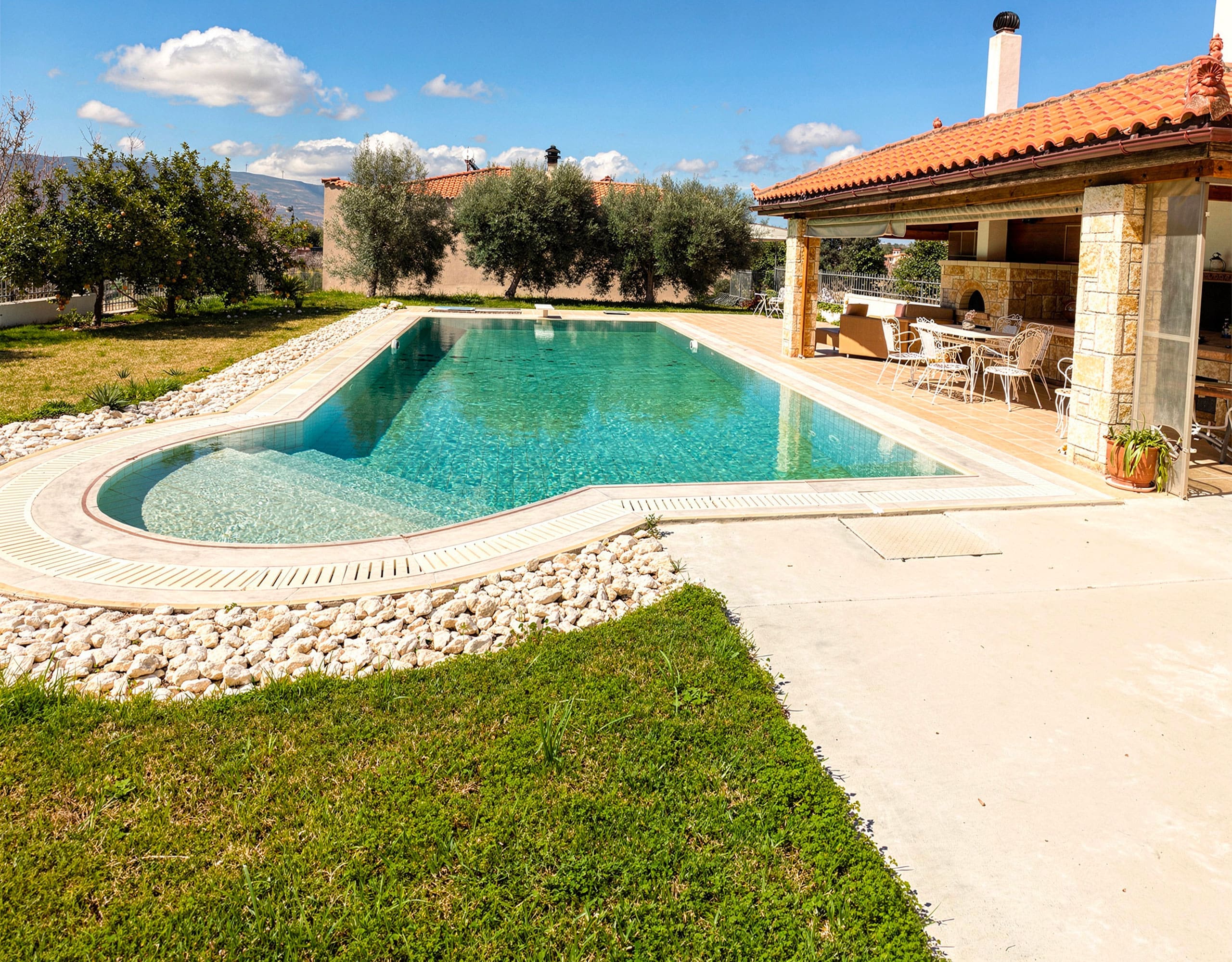 Shaded outdoor seating next to the private pool at the Eretria maisonette